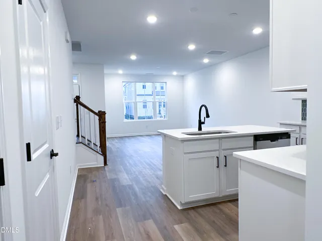 a kitchen with a sink and wooden floor