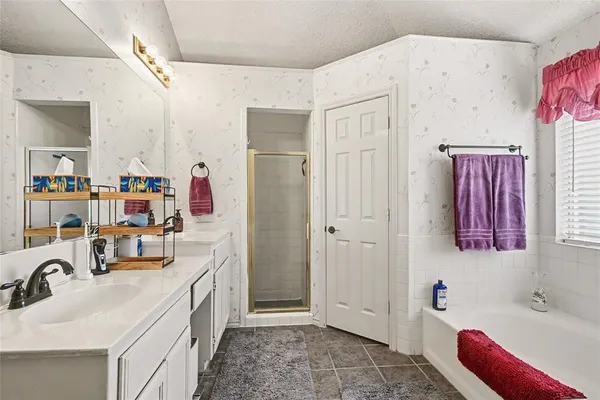 a bathroom with a sink vanity tub and shower