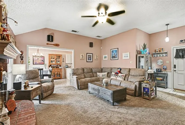 a living room with furniture kitchen view and a chandelier