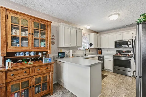 a kitchen with stainless steel appliances granite countertop a stove a sink dishwasher and a refrigerator