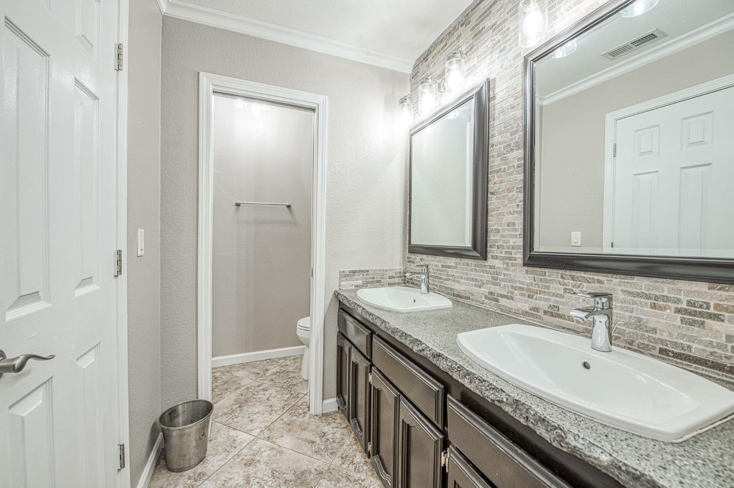 33717 River Knolls Road Coarsegold, CA 93614 - Photo 23 of 66 a bathroom with a granite countertop sink double vanity and a mirror