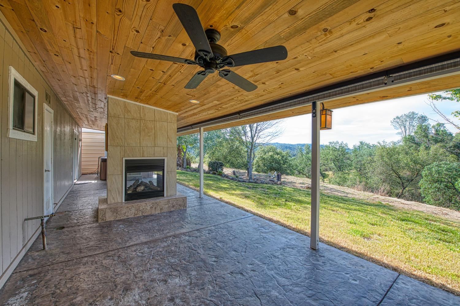 33717 River Knolls Road Coarsegold, CA 93614 - Photo 28 of 66 a view of an empty room with a fireplace and a floor to ceiling window