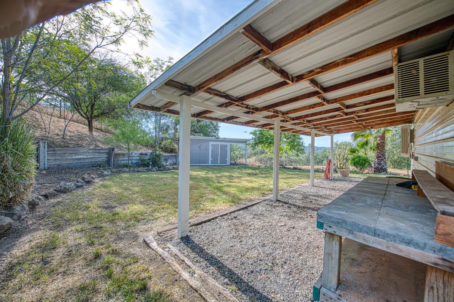 33717 River Knolls Road Coarsegold, CA 93614 - Photo 38 of 66 a view of a backyard with floor to ceiling windows and a table