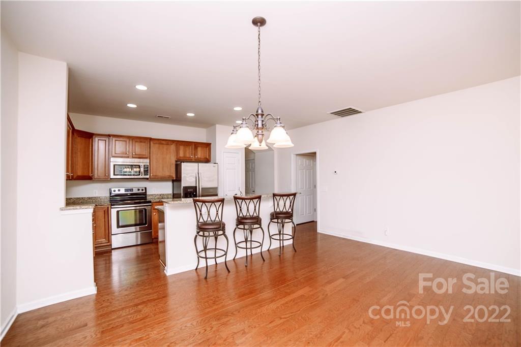 9005 Smokey Hill Road Indian Land, SC 29707 - Photo 2 of 30 a dining room with furniture wooden floor kitchen view and a chandelier