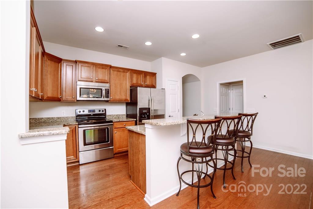 9005 Smokey Hill Road Indian Land, SC 29707 - Photo 5 of 30 a kitchen with stainless steel appliances granite countertop a stove a sink a microwave and a refrigerator