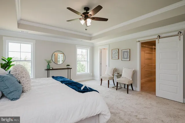 a bed room with a bed mirror table chair and a window