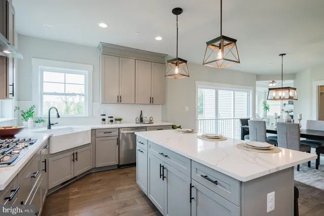 a kitchen with a stove a sink a center island and a window