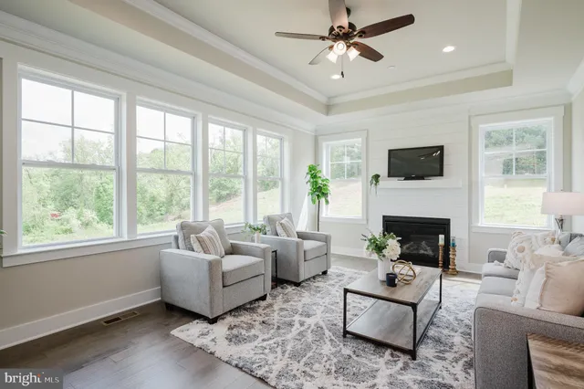 a living room with furniture a fireplace and a large window