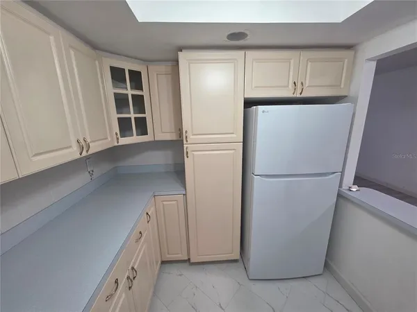 a white refrigerator freezer and a stove sitting inside of a kitchen