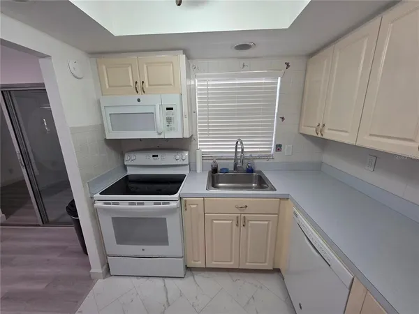 a kitchen with a stove sink and cabinets