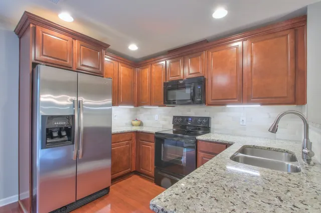 a kitchen with stainless steel appliances granite countertop a sink stove and refrigerator