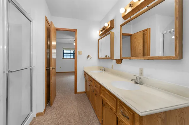 a bathroom with a double vanity sink a mirror and a bathtub