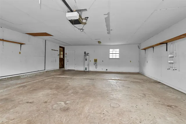 an empty room with ceiling fan and windows