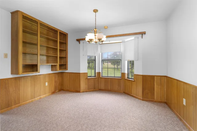 an empty room with cabinet and windows