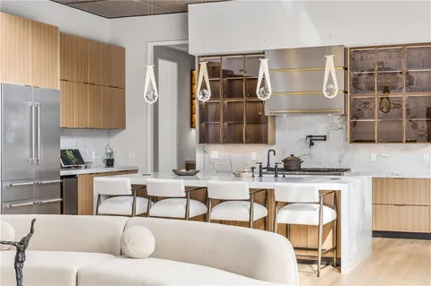 a large white kitchen with cabinets a sink a window and a couch