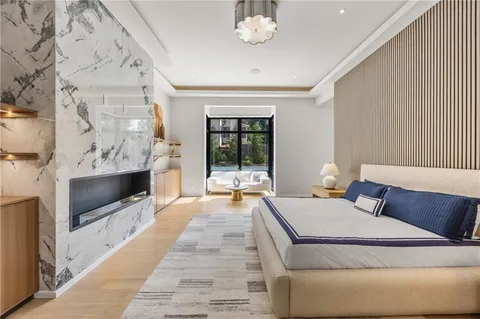a spacious bedroom with a bed a couch and a chandelier