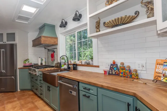 a kitchen with stainless steel appliances a sink and a stove