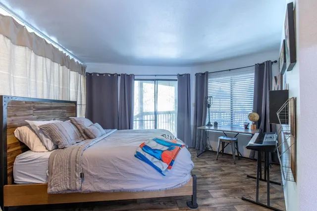 a bedroom with a bed and wooden floor