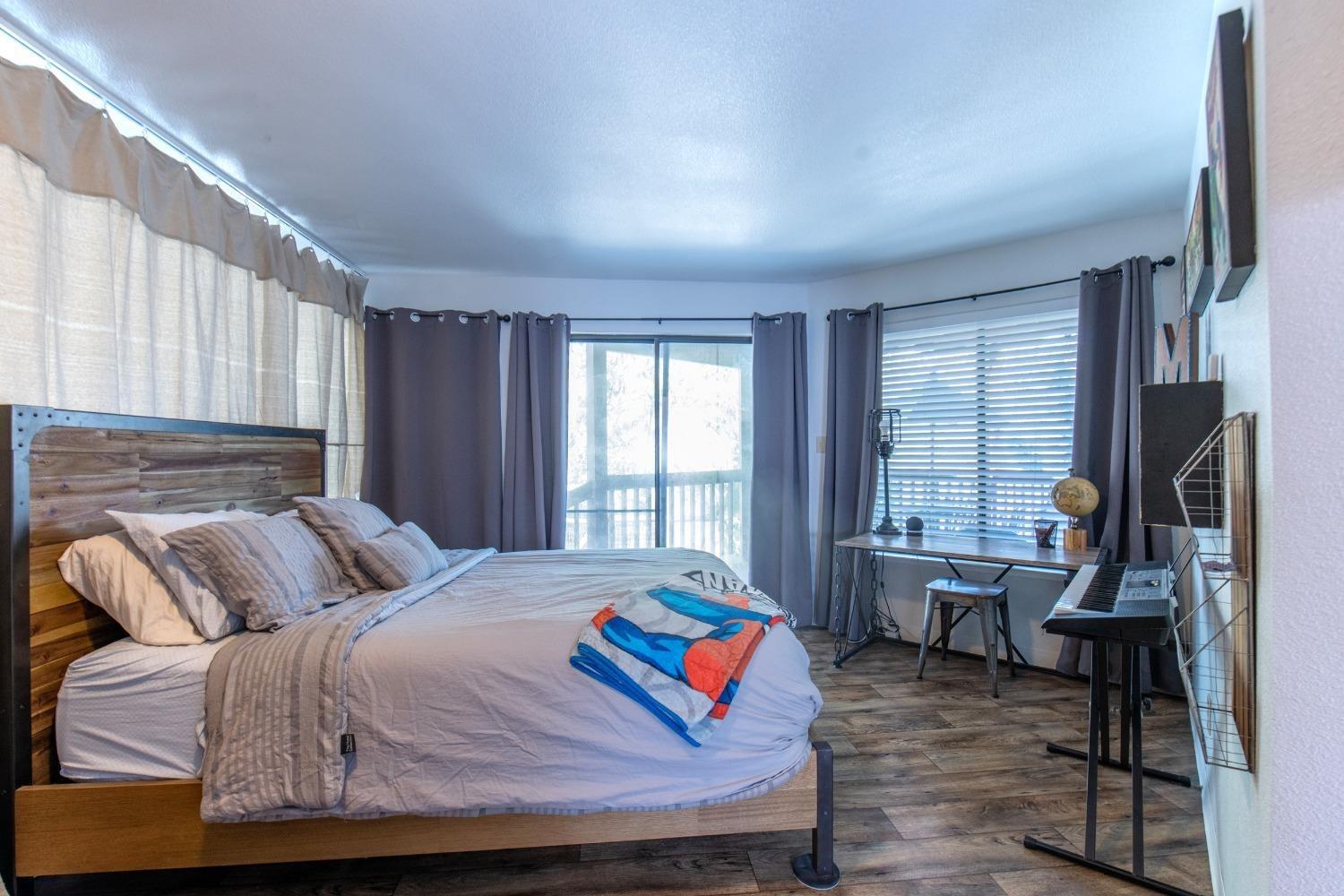 33952 Tocaloma Road Auberry, CA 93602 - Photo 19 of 39 a bedroom with a bed and wooden floor