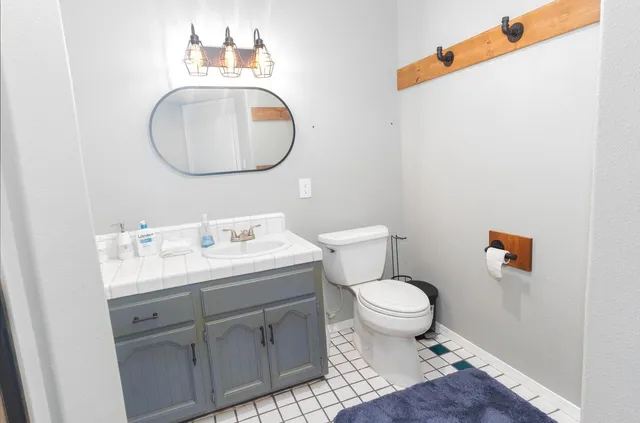a bathroom with a toilet a sink and a mirror