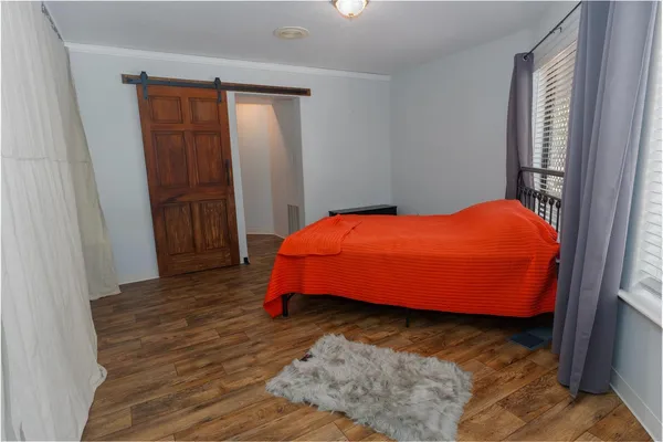 a bedroom with a bed and wooden floor