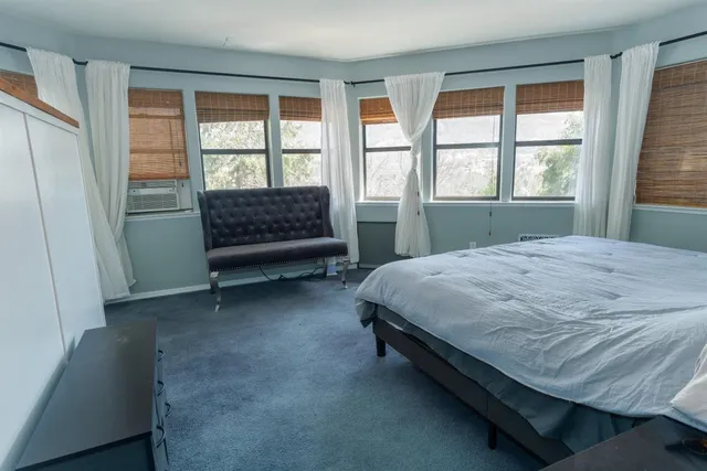 a bed sitting in a bedroom next to a window
