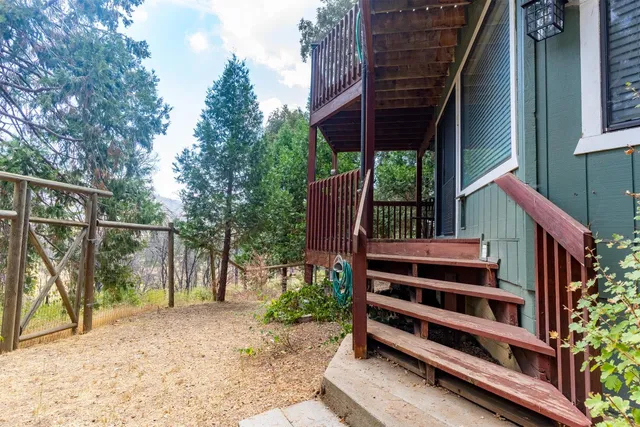 a view of a deck with table and chairs a barbeque with wooden fence and plants