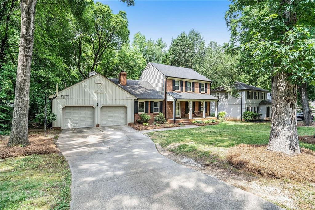 613 Neill Ridge Road Matthews, NC 28105 - Photo 2 of 25 a front view of a house with a garden and trees