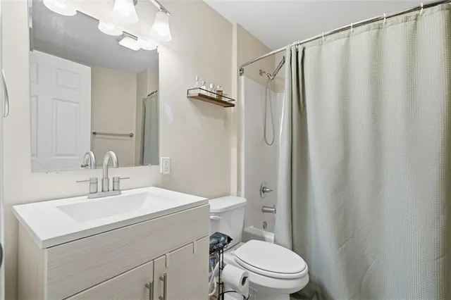 a bathroom with a sink a mirror a toilet and shower curtain