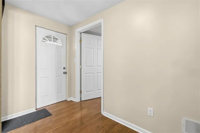 a view of an empty room with wooden floor