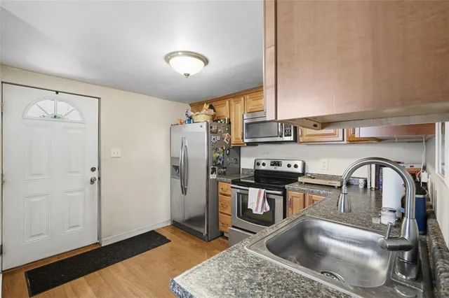 a kitchen with stainless steel appliances granite countertop a sink a stove and refrigerator