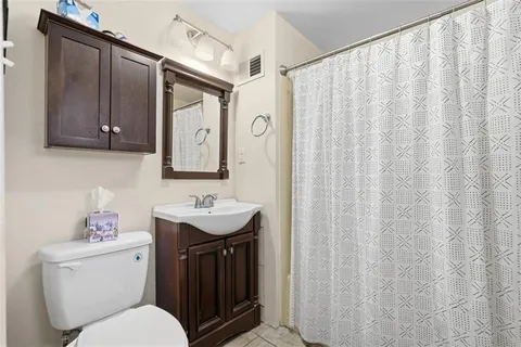 a bathroom with a toilet sink and mirror