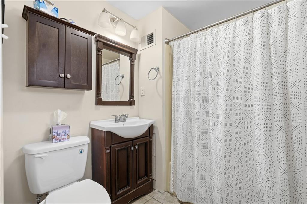 1202 Sarah Street Pittsburgh, PA 15203 - Photo 32 of 37 a bathroom with a toilet sink and mirror