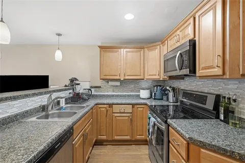 a kitchen with stainless steel appliances granite countertop a sink stove and microwave