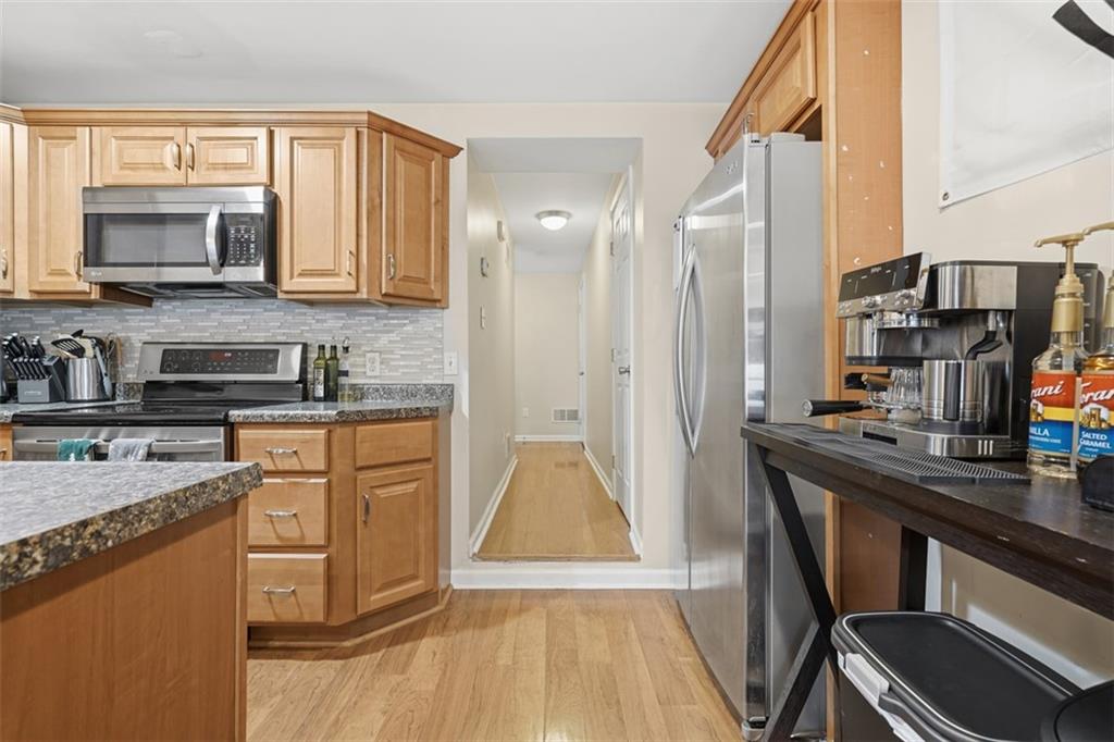 1202 Sarah Street Pittsburgh, PA 15203 - Photo 8 of 37 a kitchen with stainless steel appliances granite countertop a refrigerator a stove and a sink with wooden floor