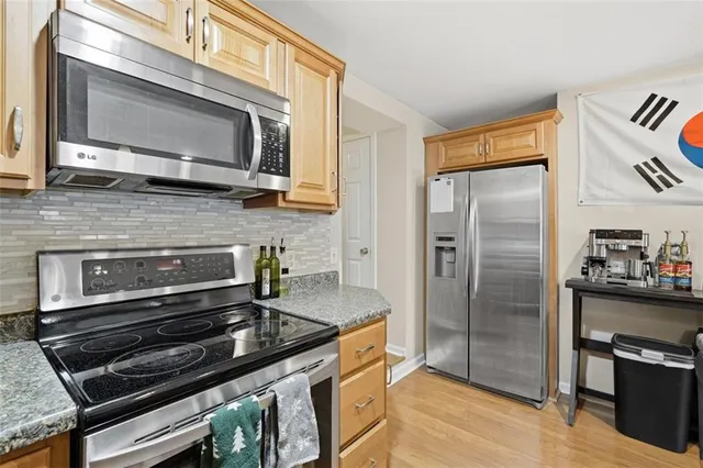 a kitchen with wooden cabinets and stainless steel appliances