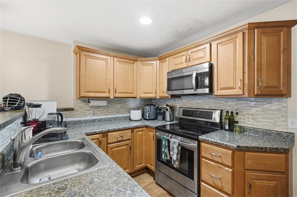 1202 Sarah Street Pittsburgh, PA 15203 - Photo 10 of 37 a kitchen with granite countertop a sink stove top oven and microwave