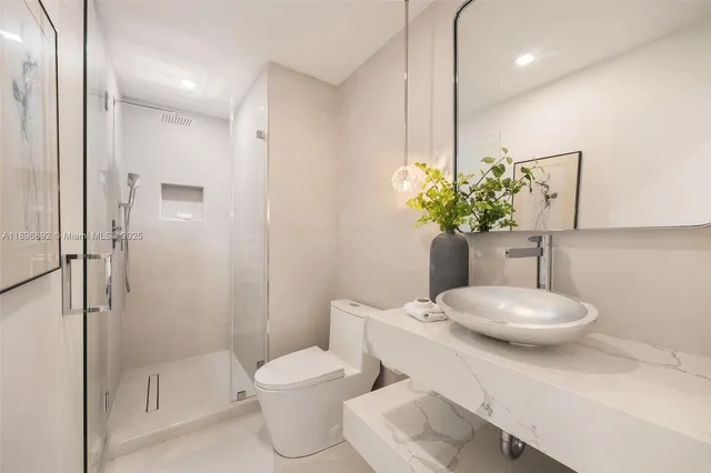 a bathroom with a toilet a sink and shower