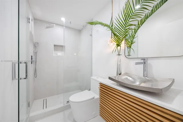 a bathroom with a sink a toilet and shower