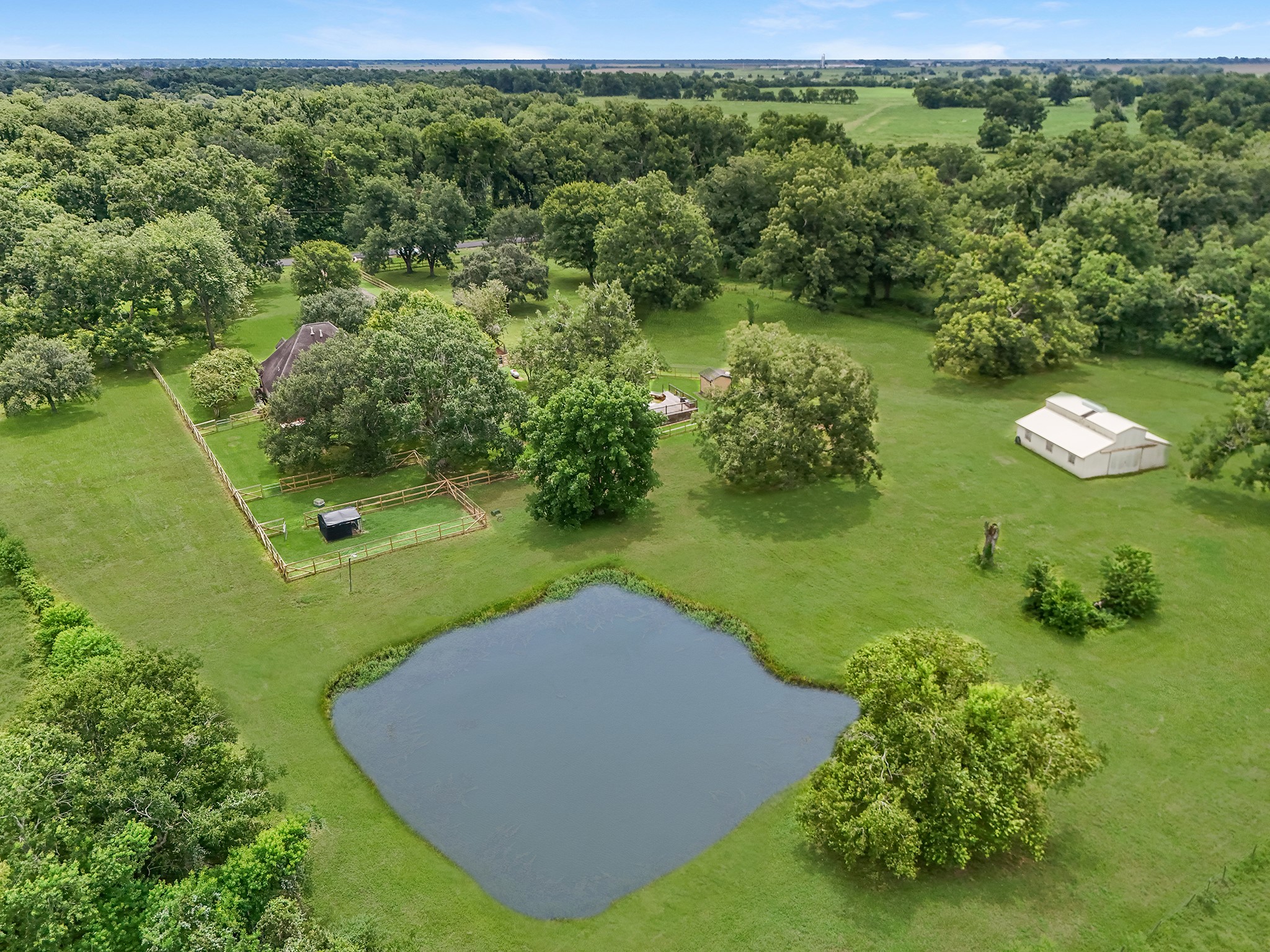 17126 County Road 39 Rosharon, TX 77583 - Photo 18 of 47 Drone view of stocked pond, barn, separate fenced area for chickens, dogs and or goats. Backyard of home fenced as well as large side yards and front.