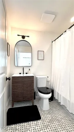 a bathroom with a sink a toilet and a mirror