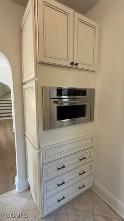 a bathroom with granite countertop cabinets and a microwave