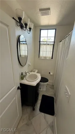 a bathroom with a sink a toilet and a mirror