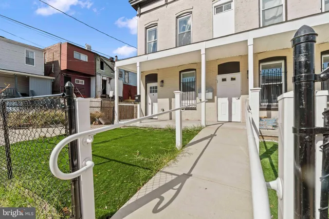 a view of a house with a yard and pathway