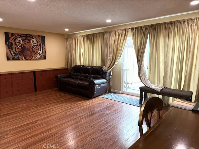 a view of a room with furniture wooden floor and windows