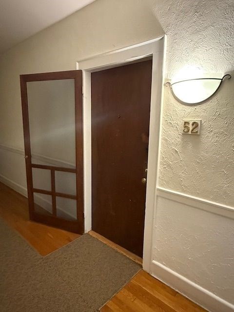 21 Bradlee Road, Unit 52 Medford, MA 02155 - Photo 15 of 22 an empty room with wooden floor and mirror
