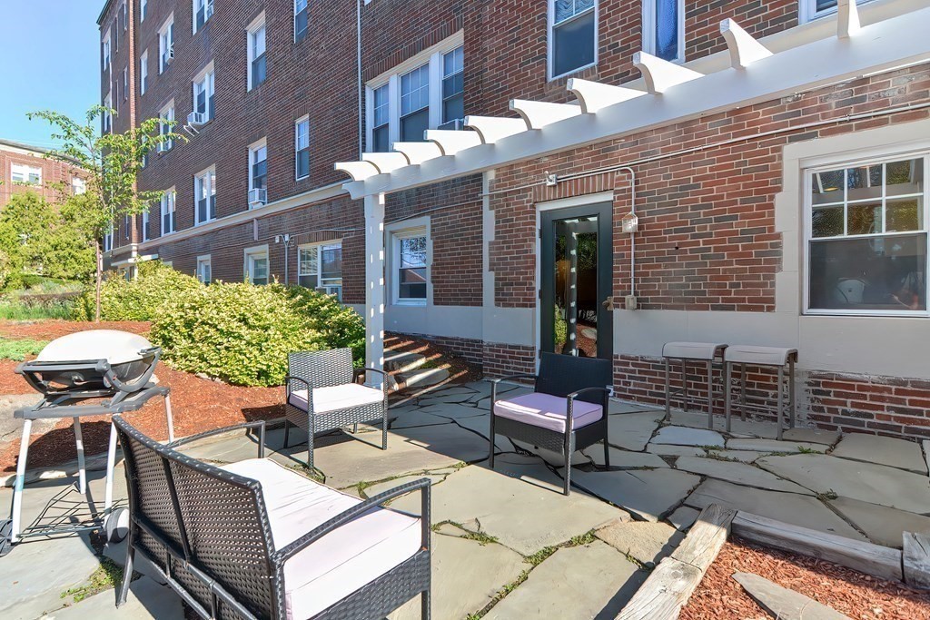 21 Bradlee Road, Unit 52 Medford, MA 02155 - Photo 20 of 22 a view of a patio with couches table and chairs and potted plants