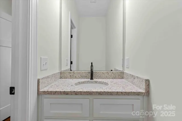 a bathroom with granite countertop double vanity
