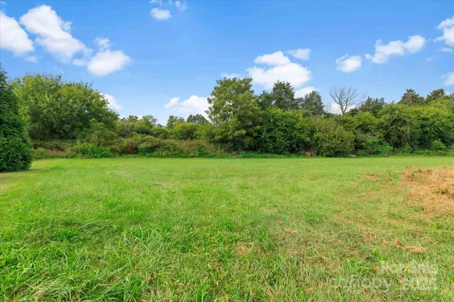 a view of a garden with a house in the background