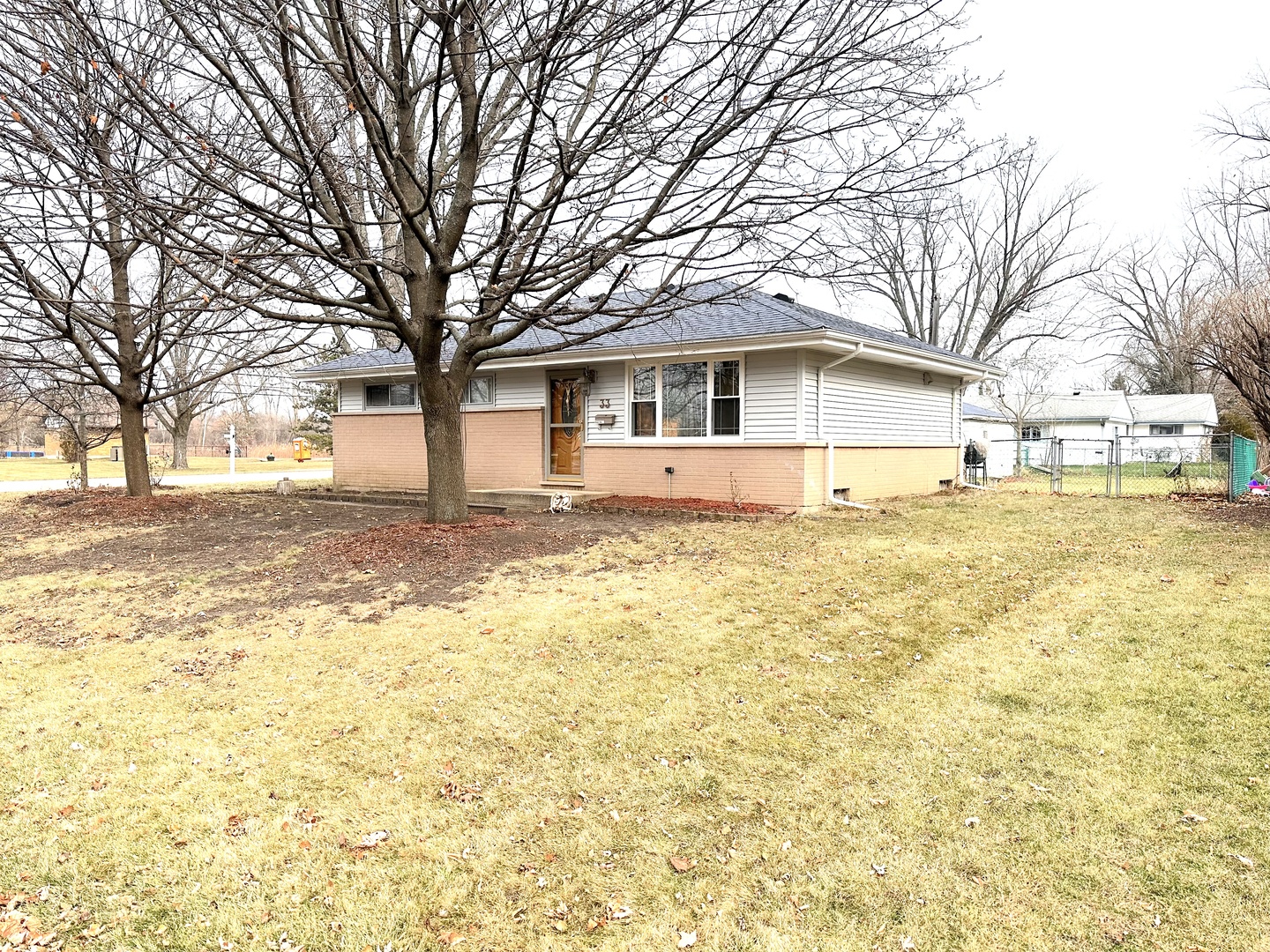 a front view of a house with a yard covered with trees